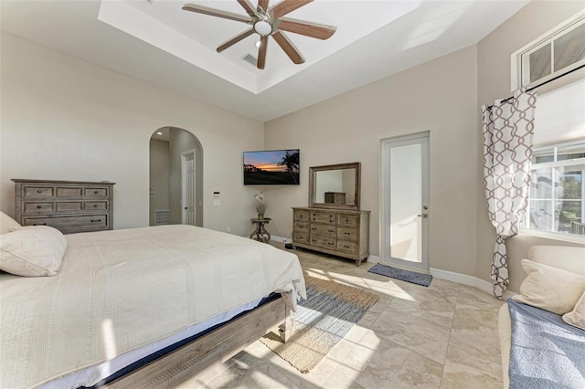 bedroom featuring a raised ceiling and ceiling fan