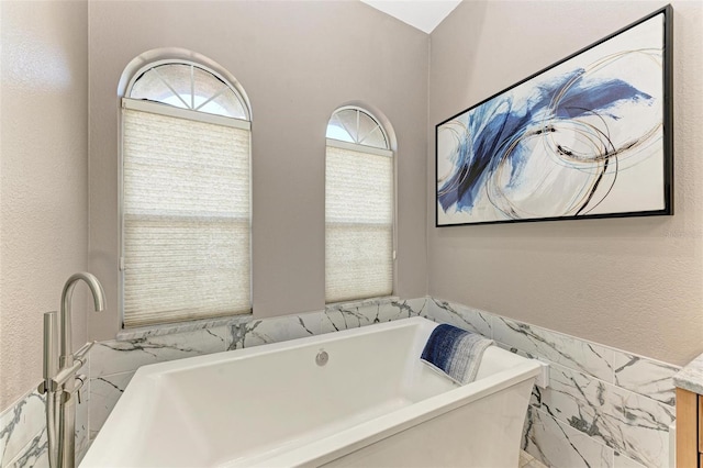 bathroom with a washtub and tile walls