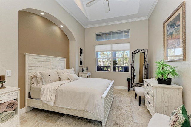 bedroom with ceiling fan, crown molding, and a high ceiling