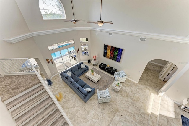 living room with ceiling fan and a high ceiling