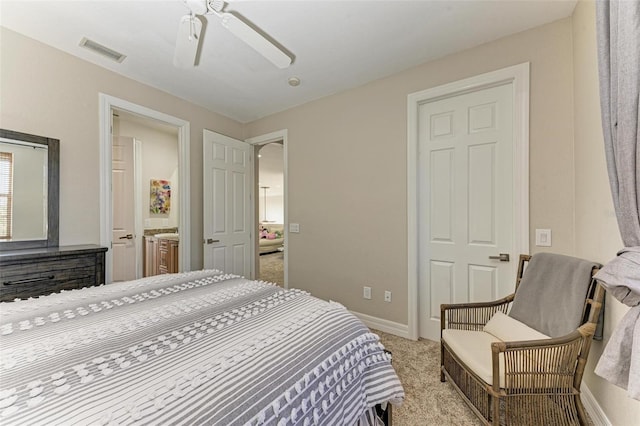 bedroom featuring ceiling fan, light colored carpet, and ensuite bathroom