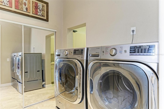 clothes washing area with separate washer and dryer and light tile patterned floors