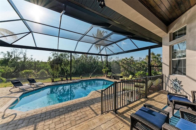 view of pool with glass enclosure and a patio