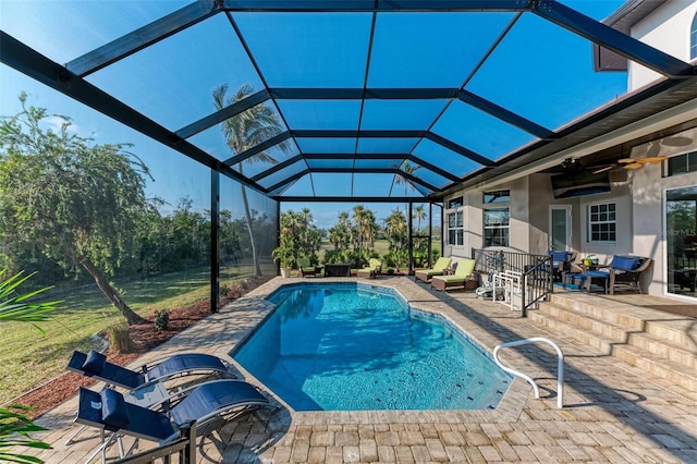 view of pool featuring ceiling fan, a patio area, and a lanai