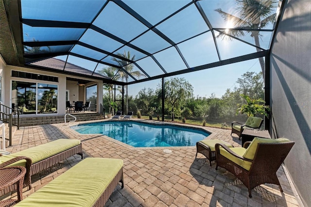 view of pool featuring an outdoor living space, a patio area, ceiling fan, and a lanai