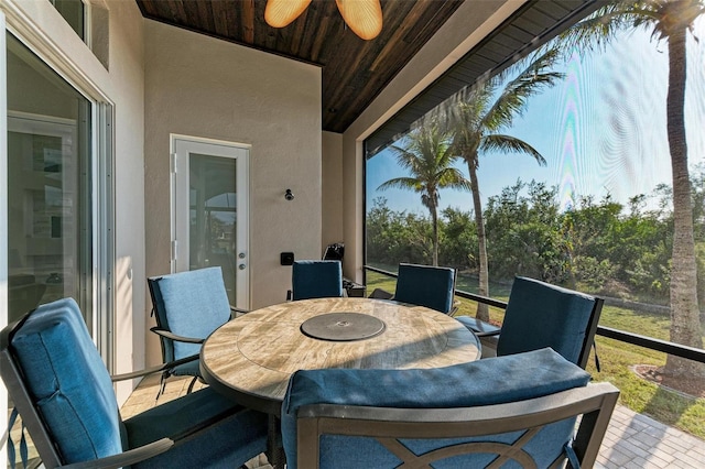 sunroom / solarium with lofted ceiling, ceiling fan, and wooden ceiling