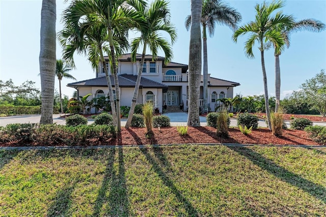 mediterranean / spanish-style house with a front yard and a balcony