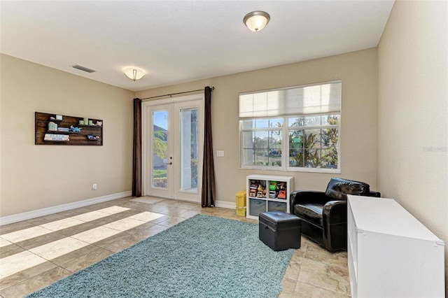 living area with french doors and light tile patterned floors