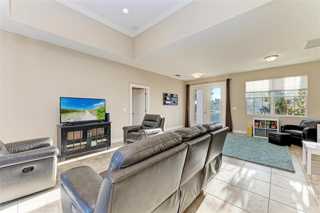 living room featuring a tray ceiling, ornamental molding, french doors, and light tile patterned flooring