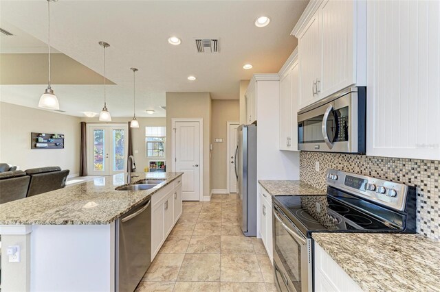 kitchen featuring pendant lighting, sink, appliances with stainless steel finishes, a kitchen island with sink, and white cabinetry