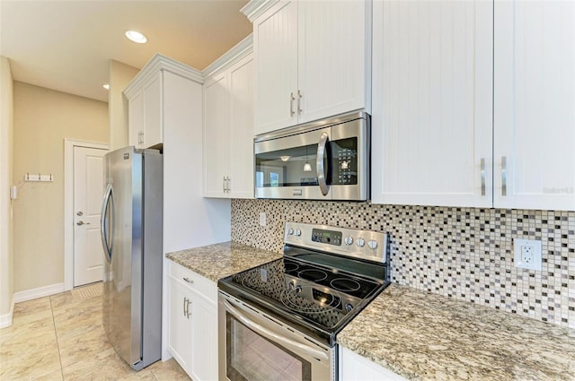 kitchen featuring white cabinetry, decorative backsplash, light tile patterned floors, light stone counters, and stainless steel appliances