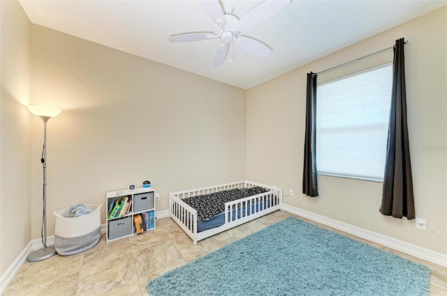 bedroom with a crib and ceiling fan