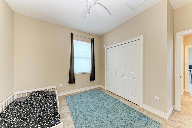 unfurnished bedroom with ceiling fan and a closet