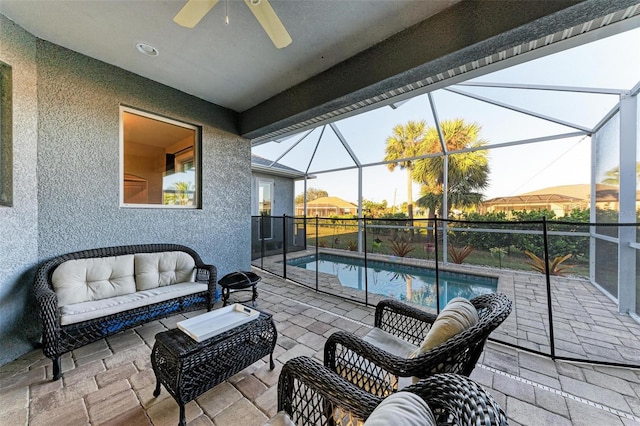 view of patio featuring a lanai, outdoor lounge area, and ceiling fan