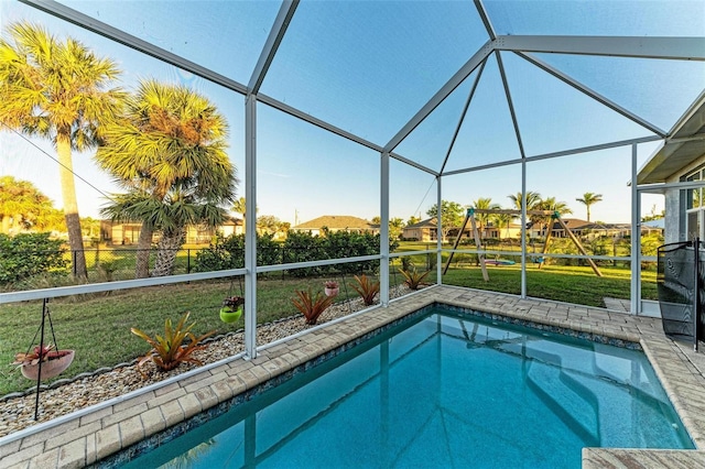 view of swimming pool featuring a lanai and a yard