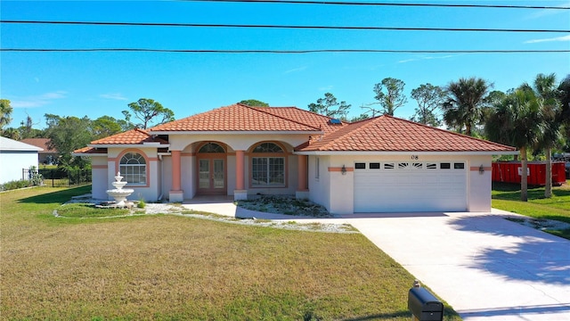 mediterranean / spanish-style house featuring a front lawn and a garage