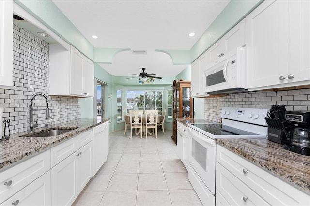 kitchen featuring sink, light stone counters, backsplash, white appliances, and white cabinets