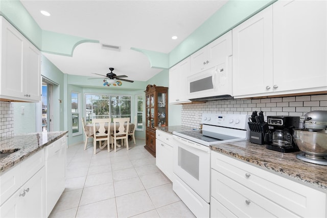 kitchen featuring decorative backsplash, white cabinets, and white appliances