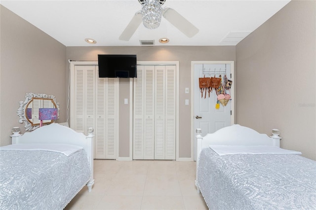 bedroom with two closets, ceiling fan, and light tile patterned flooring