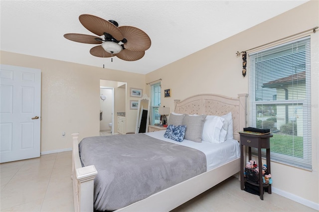 tiled bedroom featuring ceiling fan and ensuite bath