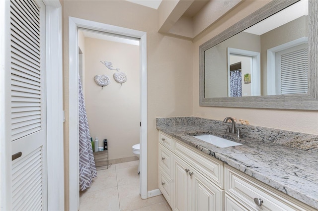 bathroom featuring tile patterned flooring, vanity, and toilet