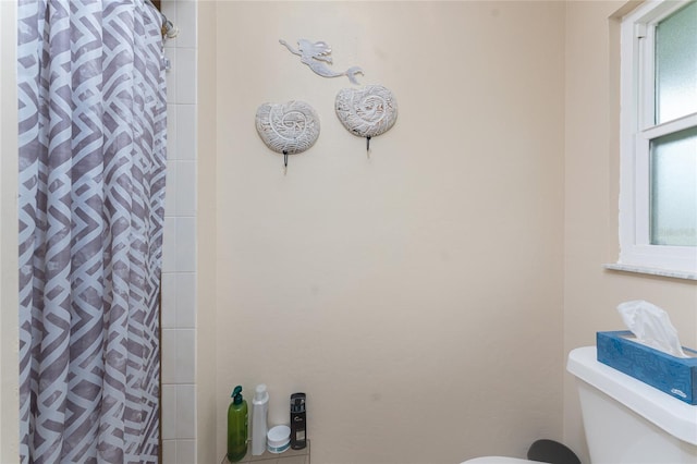 bathroom with curtained shower and toilet