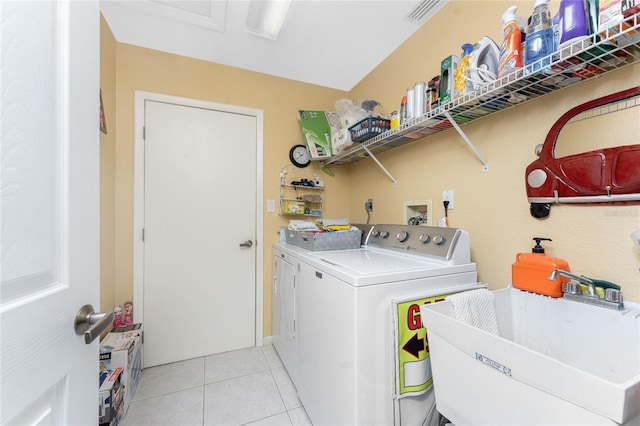 laundry room featuring sink, light tile patterned floors, and washer and dryer