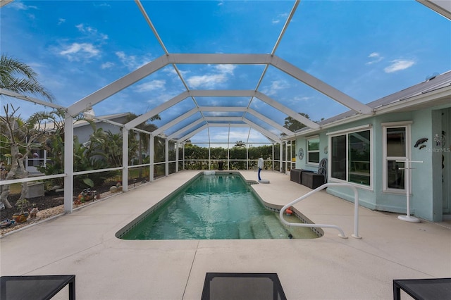 view of swimming pool with glass enclosure and a patio