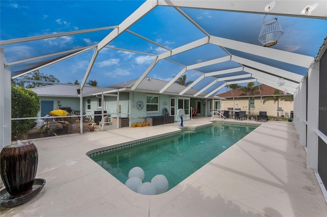 view of pool featuring glass enclosure and a patio area