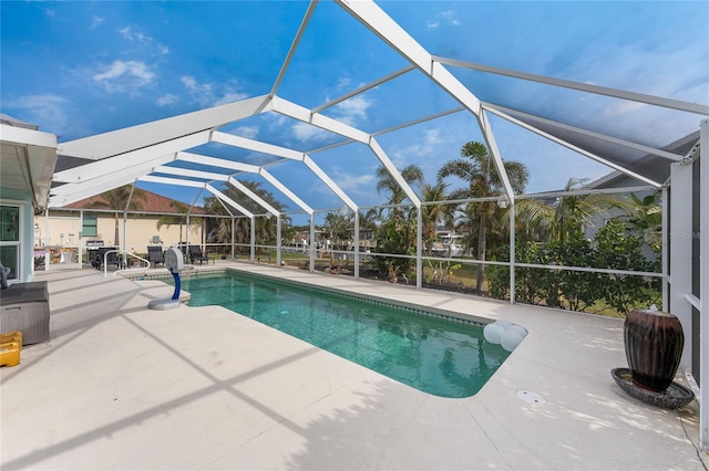 view of pool with glass enclosure and a patio