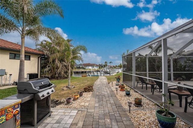 view of patio featuring a lanai and a water view