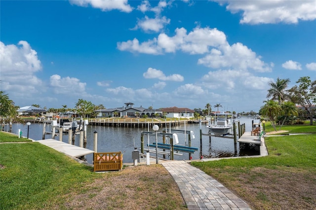 dock area with a lawn and a water view