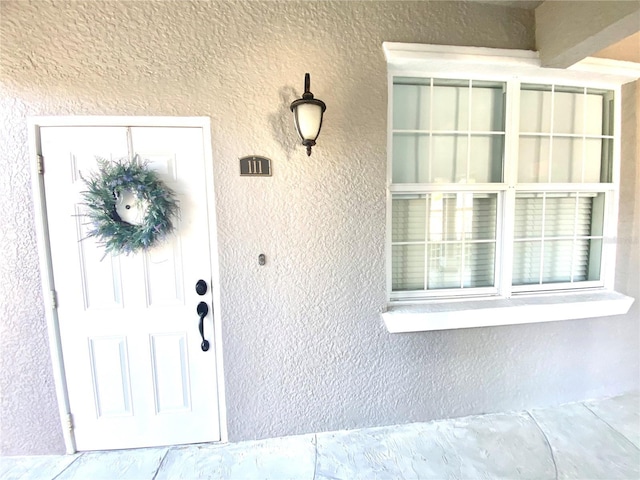 property entrance with stucco siding