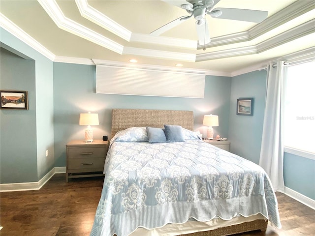 bedroom featuring crown molding, dark hardwood / wood-style floors, ceiling fan, and a tray ceiling