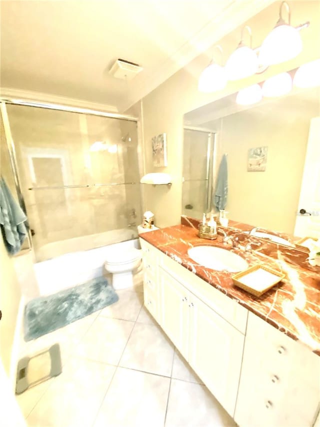 full bathroom featuring bath / shower combo with glass door, vanity, ornamental molding, toilet, and tile patterned floors