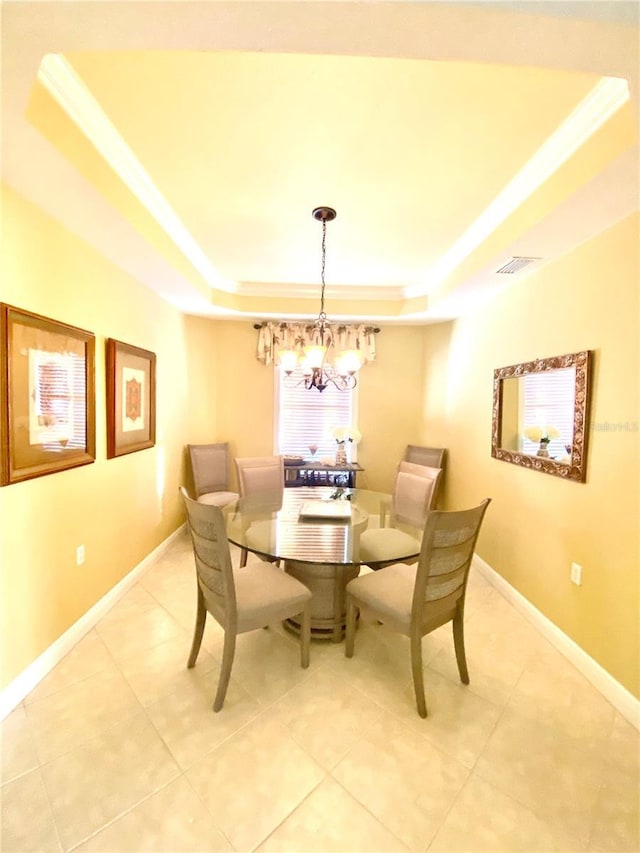 dining room featuring a tray ceiling, baseboards, visible vents, and an inviting chandelier