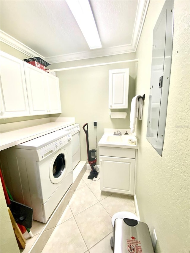 clothes washing area featuring ornamental molding, light tile patterned floors, washer / dryer, cabinet space, and a sink