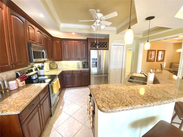 kitchen with ornamental molding, a sink, backsplash, stainless steel appliances, and a raised ceiling