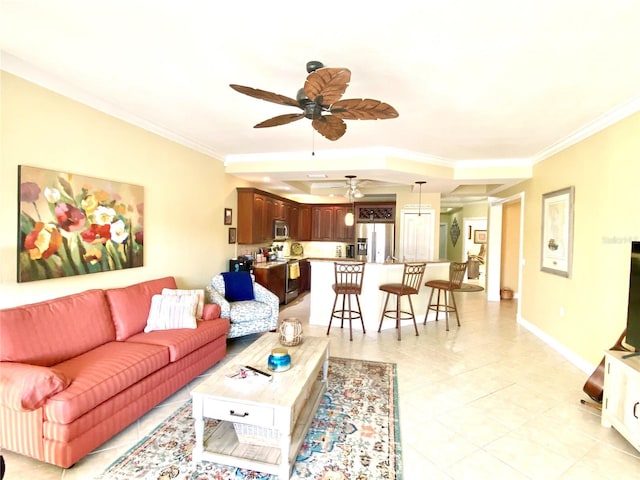 living area with light tile patterned floors, a ceiling fan, crown molding, and baseboards