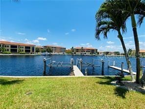 view of dock with a water view and a lawn