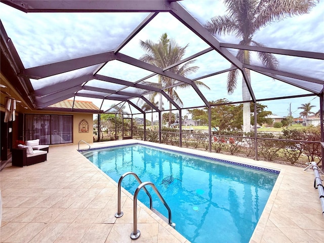 view of pool with glass enclosure and a patio