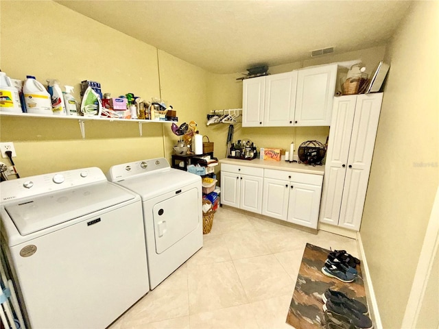 laundry area featuring light tile patterned flooring, cabinets, and independent washer and dryer