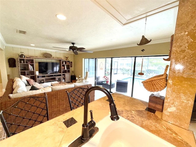 interior space featuring ceiling fan, ornamental molding, and sink