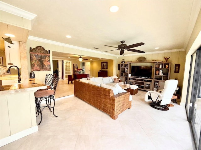 living room with ceiling fan, sink, and ornamental molding