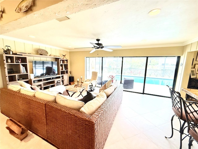 living room featuring ceiling fan, a healthy amount of sunlight, light tile patterned floors, and crown molding