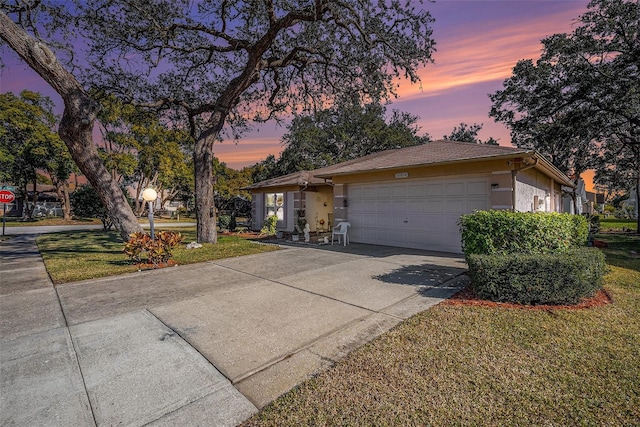 single story home featuring a lawn and a garage