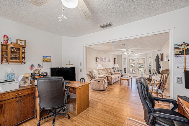 office space with a textured ceiling, light hardwood / wood-style flooring, and ceiling fan