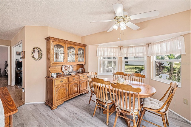 dining space with a textured ceiling, light hardwood / wood-style floors, and ceiling fan