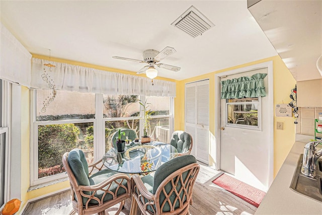 sunroom / solarium featuring ceiling fan