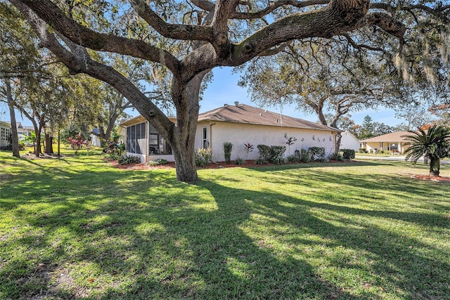 view of side of property with a yard and a sunroom